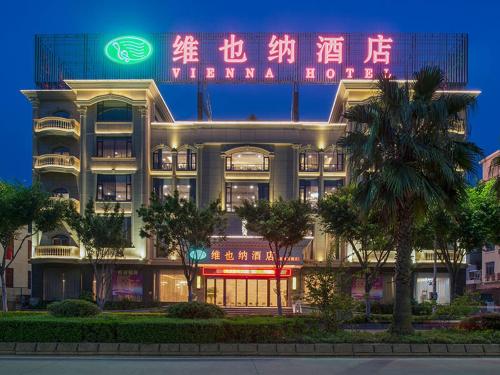 a building with a neon sign in front of it at Vienna Hotel (Quanzhou West Lake Store) in Quanzhou