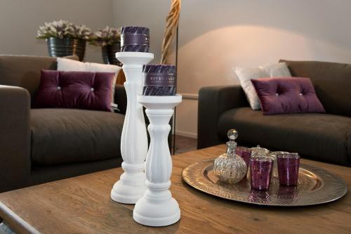 a table with two white vases and some glasses on it at Grenshotel de Jonckheer in Ossendrecht