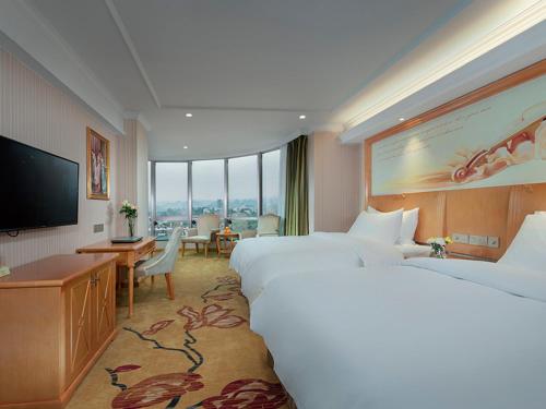 a hotel room with two beds and a flat screen tv at Vienna Classic hotel(Lianzhou Building Branch) in Lianzhou