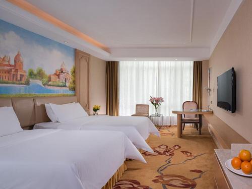 a hotel room with two beds and a television at Vienna Hotel (Shajinbei Road Fuquan Guizhou) in Fuquan