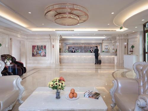 a man standing in a large room with a lobby at Vienna Hotel (East Plaza of WuHan High-Speed Railway Station) in Wuhan
