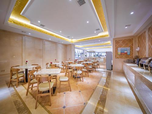 a dining room with tables and chairs in a restaurant at vienna hotel (HuaZhong Agricultural University in South Lake Store) in Wuhan