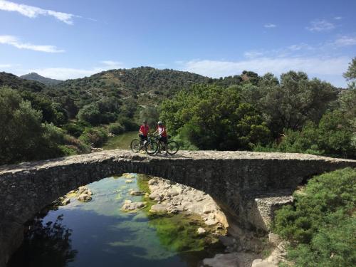 two people riding bikes on a bridge over a river at Galini Breeze in Agia Galini
