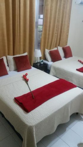 two beds in a room with red napkins on them at MH Boutique Hotel in San Pedro Sula
