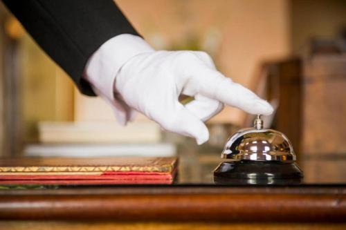 a person in white gloves reaching for a bell at Premier Hotel The Richards in Richards Bay