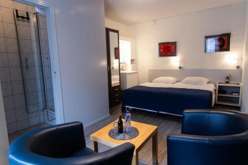 een hotelkamer met een bed en twee stoelen bij Gastenverblijf 't Smedenhuys in Maasbracht