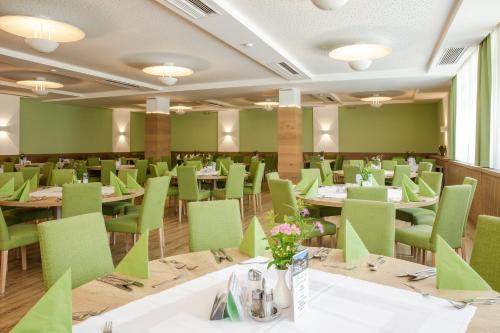 jadalnia ze stołami i zielonymi krzesłami w obiekcie Seminar- & Sporthotel Freunde der Natur w mieście Spital am Pyhrn
