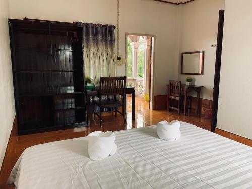 a bedroom with a bed with two pillows on it at Dalom Guesthouse in Don Det