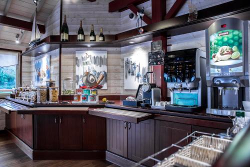 a bar in a restaurant with a counter with alcohol at Kyriad Saint-Malo Dinard in La Richardais