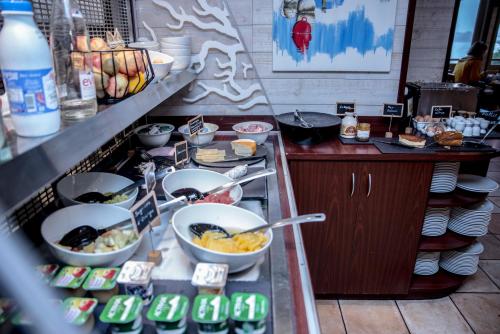 a buffet line with bowls of food in a restaurant at Kyriad Saint-Malo Dinard in La Richardais