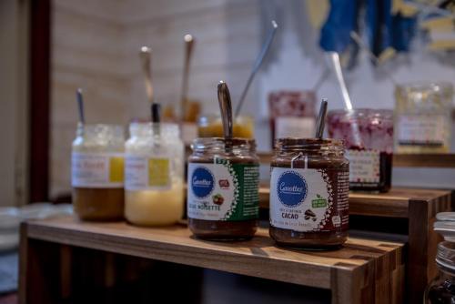 a group of jars of honey on a wooden shelf at Kyriad Saint-Malo Dinard in La Richardais