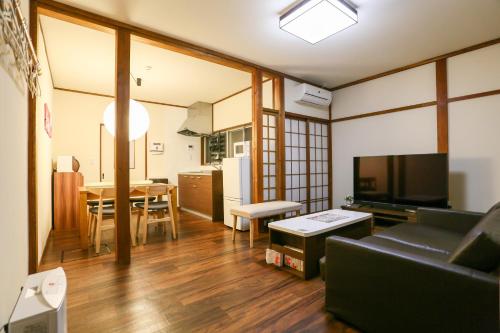 a living room with a couch and a dining room at Private House HidaTakayama in Takayama