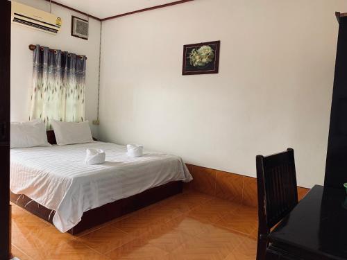 a bedroom with a bed with two towels on it at Dalom Guesthouse in Don Det