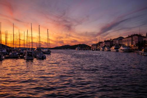 a group of boats docked in a harbor at sunset at Hotel Bellevue in Mali Lošinj