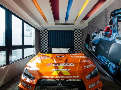 an orange race car bed in a room with windows at Kung Shang Design Hotel in Kaohsiung
