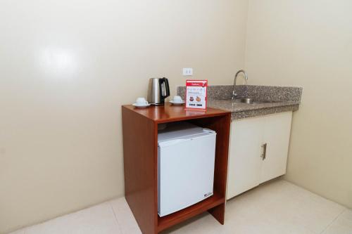 a small kitchen with a sink and a small refrigerator at RedDoorz near Osmena Highway 1 in Manila