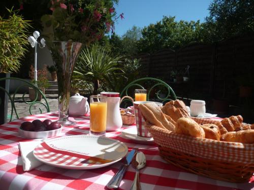 - une table de pique-nique avec un panier de pain et du jus d'orange dans l'établissement Hôtel La Résidence, à Villeneuve-sur-Lot