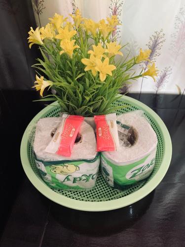 a plate with two towels and a vase with flowers at Dalom Guesthouse in Don Det
