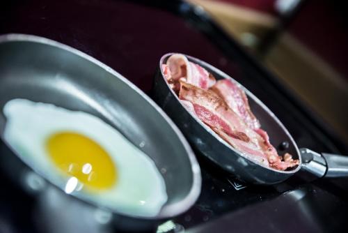 a frying pan with a fried egg and bacon at Mercure Dinan Port Le Jerzual in Dinan