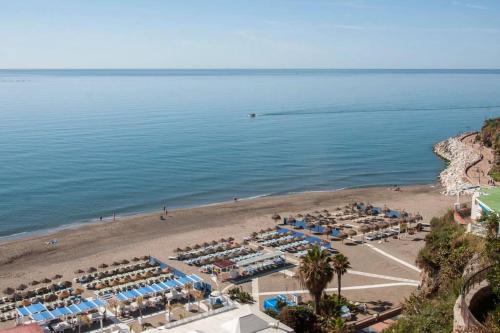 an aerial view of a beach with chairs and the ocean at SUNSET BEACH Charming apartment with jacuzzi in Torremolinos