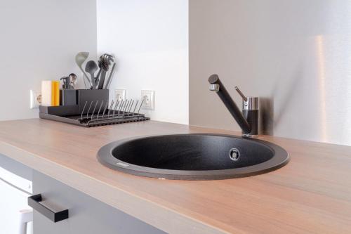 a black sink on a counter in a kitchen at Copenhagen Go Hotel in Copenhagen