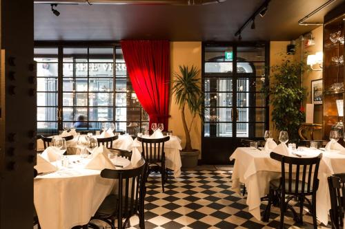 a restaurant with white tables and chairs and a red curtain at Speronari Suites in Milan
