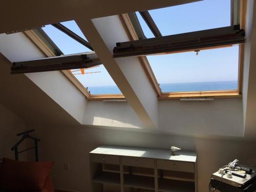two skylight windows in a room with a table at First line beach apartment in Algarrobo