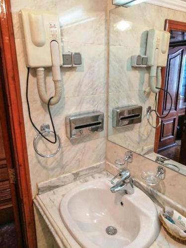 a bathroom with a sink and a phone on the wall at King Tut I Nile Cruise - Every Monday 4 Nights from Luxor - Every Friday 7 Nights from Aswan in Luxor