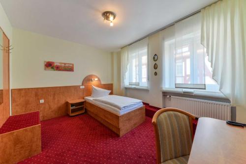 une chambre d'hôtel avec un lit et une table. dans l'établissement Hotel Kirchhainer Hof, à Kirchhain