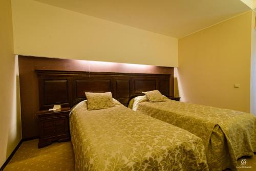 ein Hotelzimmer mit 2 Betten und einem Kopfteil in der Unterkunft Apartament Alpin resort etaj 7 in Poiana Brașov