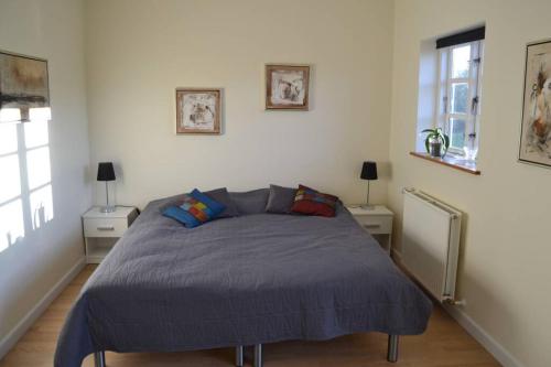 sypialnia z łóżkiem z niebieską kołdrą w obiekcie Mosborg w mieście Ulfborg