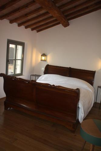 a bedroom with a large wooden bed with white sheets at Il Gesuita in Mantova