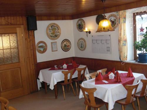 a dining room with two tables with red napkins at Schwarzer Adler in Schwaighausen