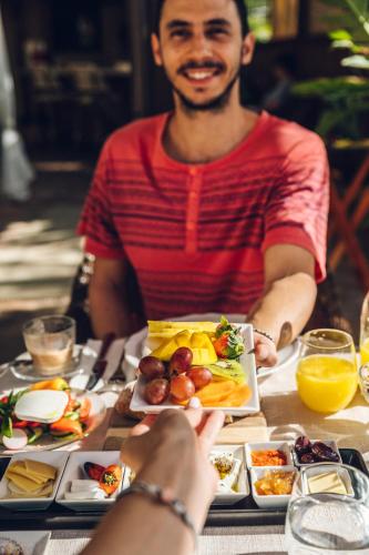 a man sitting at a table with a plate of food at Cnaan Village Boutique Hotel & Spa in Had Nes