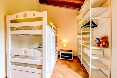 une chambre avec des lits superposés blancs dans une pièce dans l'établissement Casa Delisa, à Manerba del Garda