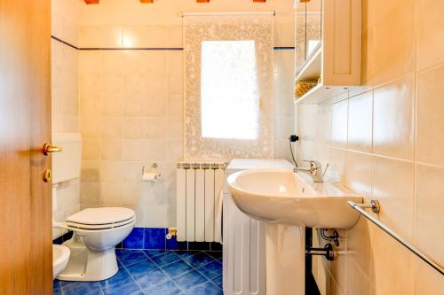 y baño con aseo blanco y lavamanos. en Casa Delisa, en Manerba del Garda