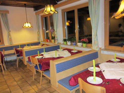 un ristorante con tavoli e sedie in una stanza di Haus Brunhilde a Fusch an der Glocknerstrasse