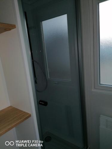 a glass door in a bathroom with a window at BVCO LOCATIONS PROCHE CHATEAUX ET BEAUVAL DANS LE LOIR et CHER in Onzain