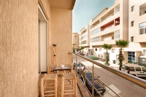 a balcony with a table and chairs and a street at FRESH DESIGNED next to THE SEA -nice area - wifi in Essaouira