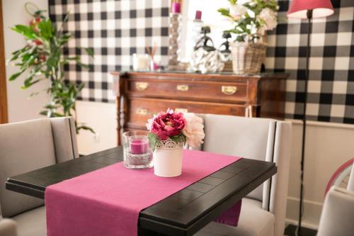 a table with a pink table cloth and a vase of flowers at Hotel Jávea in Jávea