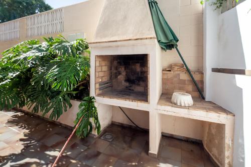 a fireplace on a patio with a green umbrella at Gandia Confort Treviso in Gandía