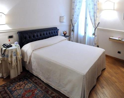 a bedroom with a large bed with a black headboard at Ristorante Albergo Ca' Vittoria in Tigliole
