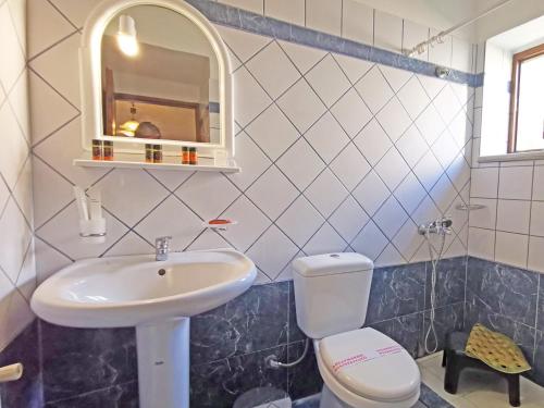 a bathroom with a sink and a toilet and a mirror at Guesthouse Toxotis in Pirgos Dhirou