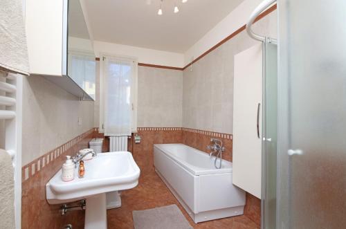 een badkamer met een wastafel, een bad en een toilet bij Il Cedro in Salò
