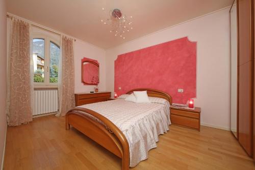 een slaapkamer met een groot bed en een rode muur bij Il Cedro in Salò
