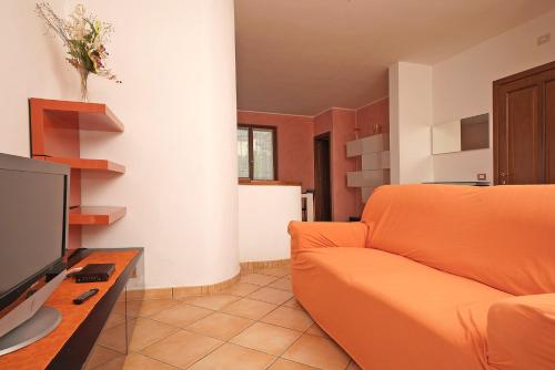 a living room with an orange couch and a television at Infinity in Tignale
