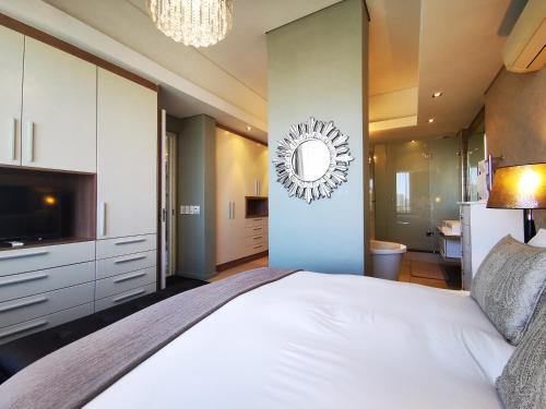 ケープタウンにあるCrystal Towers 208 Luxury 2 Bedroom Apartmentのベッドルーム(大型ベッド1台、鏡付)