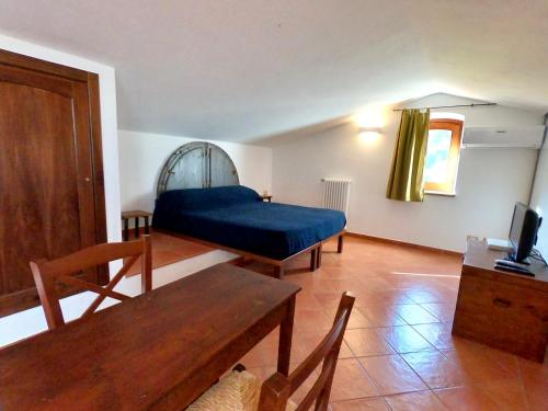 a living room with a blue bed and a table at B&B Le Ginestre in Cefalù