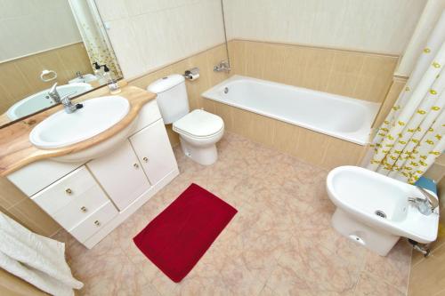 a bathroom with a sink and a toilet and a tub at Bahia Azul VyB in Denia