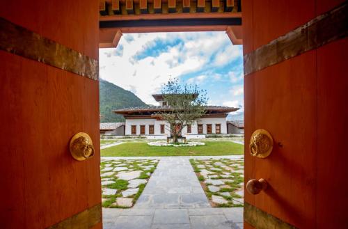 an open door to a building with a tree in the yard at Bhutan Spirit Sanctuary in Paro
